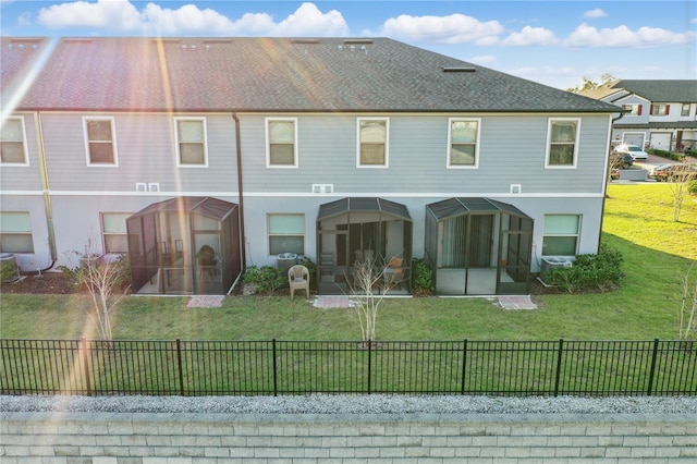 back of house featuring a sunroom, a yard, and fence