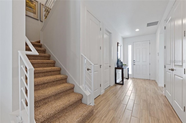 entryway with recessed lighting, visible vents, baseboards, stairway, and light wood-type flooring