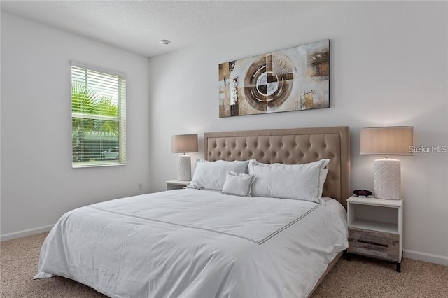 carpeted bedroom featuring baseboards and a textured ceiling