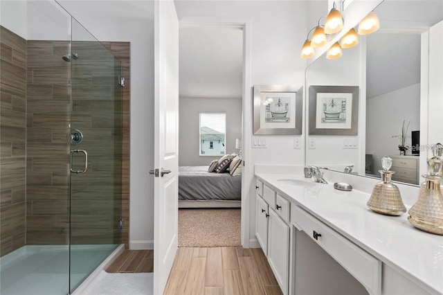 full bath featuring vanity, wood tiled floor, a stall shower, ensuite bath, and an inviting chandelier