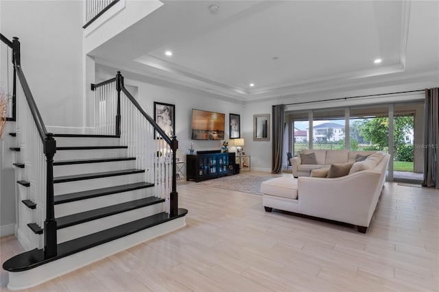 living area with recessed lighting, wood finished floors, stairway, a raised ceiling, and crown molding