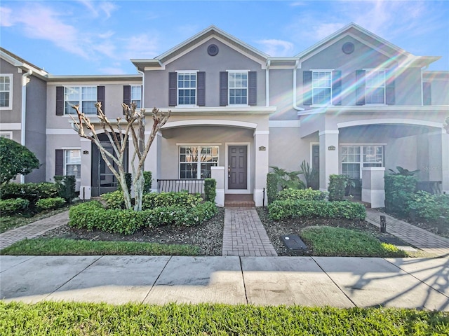 multi unit property featuring covered porch and stucco siding