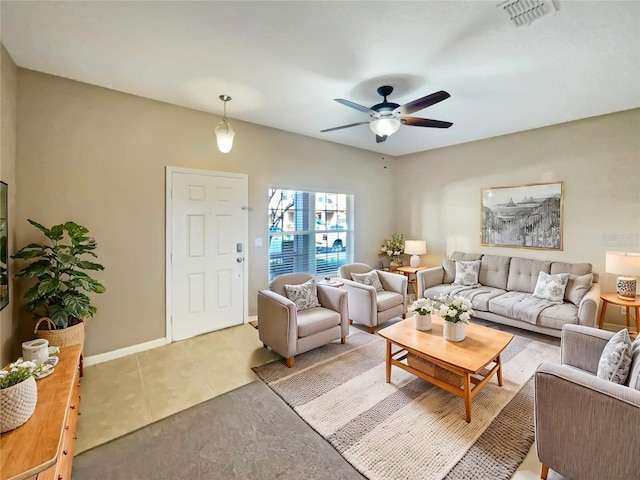 living room featuring light tile patterned floors, baseboards, visible vents, and a ceiling fan