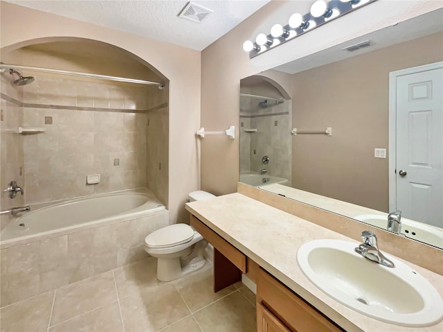 bathroom featuring tiled shower / bath, toilet, tile patterned flooring, and visible vents