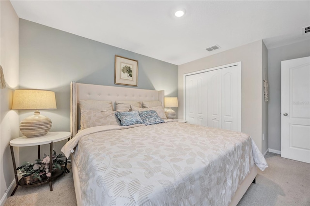 carpeted bedroom featuring visible vents, a closet, and baseboards