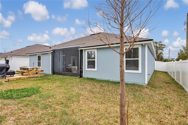 back of property featuring stucco siding, a fenced backyard, a yard, a sunroom, and a patio area