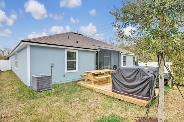 back of house with a shingled roof, a wooden deck, central AC unit, a fenced backyard, and a yard