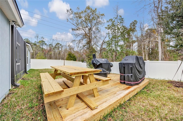 view of yard featuring a wooden deck, a fenced backyard, and outdoor dining space