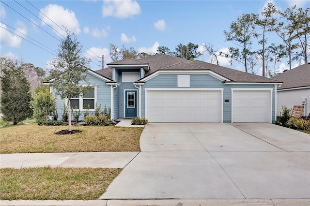 view of front of house with concrete driveway, a front yard, a garage, and a shingled roof