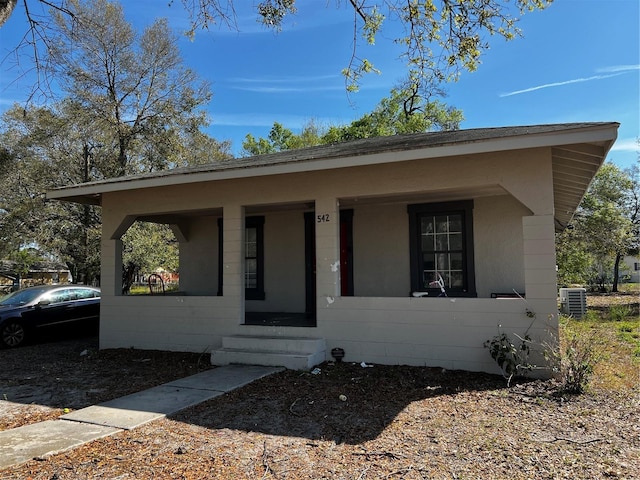 bungalow-style home with central air condition unit and covered porch