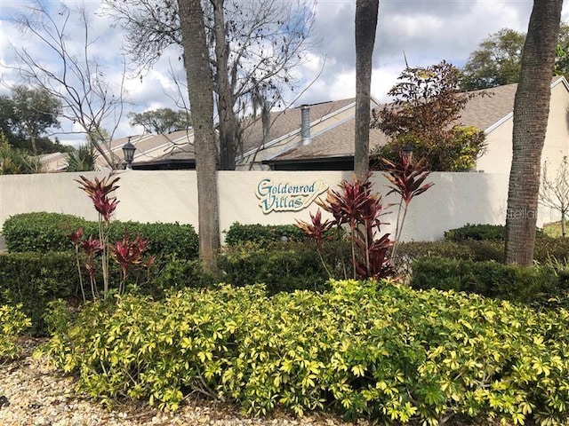 community / neighborhood sign featuring fence