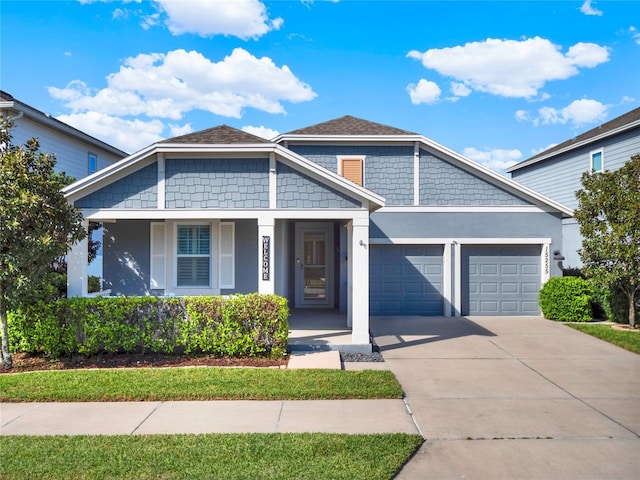 view of front of property with driveway, an attached garage, and stucco siding