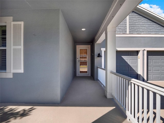 doorway to property featuring a garage and stucco siding