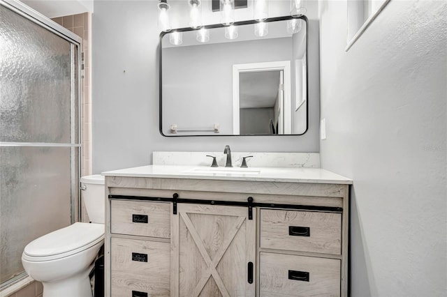 bathroom featuring a stall shower, vanity, and toilet