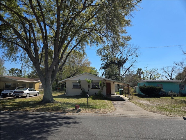 view of front of property with a carport, driveway, and a front lawn