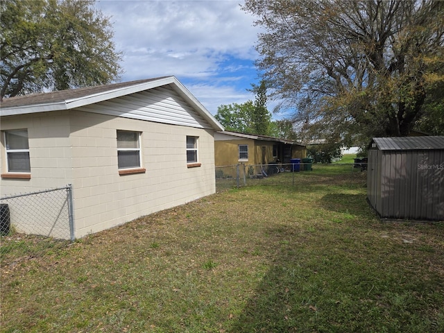 view of yard with a storage unit, an outbuilding, and fence