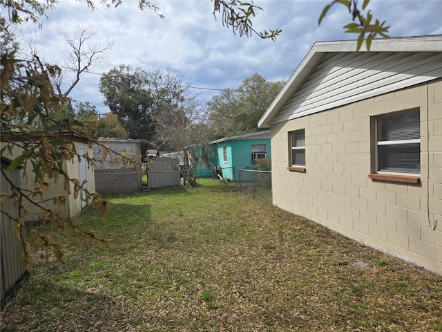 view of yard featuring an outdoor structure, a fenced backyard, and a shed