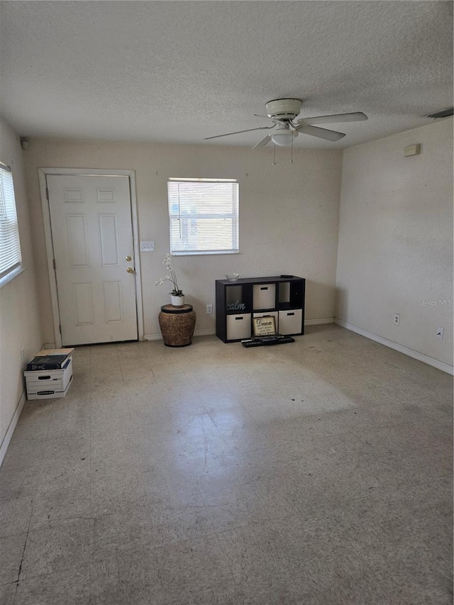 interior space with tile patterned floors, a textured ceiling, a healthy amount of sunlight, and ceiling fan