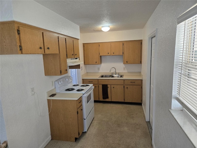 kitchen with under cabinet range hood, light floors, light countertops, white electric stove, and a sink