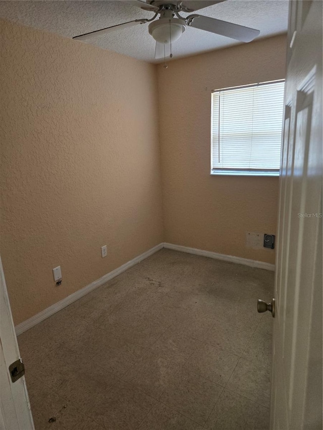 empty room with a ceiling fan and baseboards