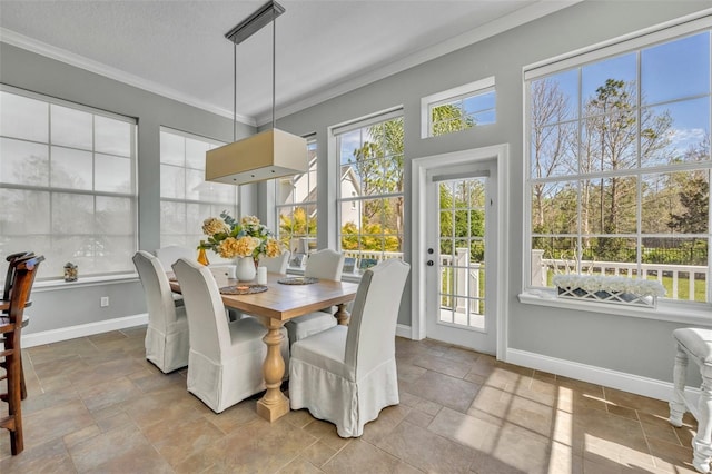 dining area featuring stone tile flooring, crown molding, a textured ceiling, and baseboards