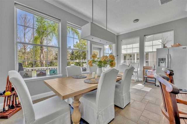 dining space with baseboards and crown molding