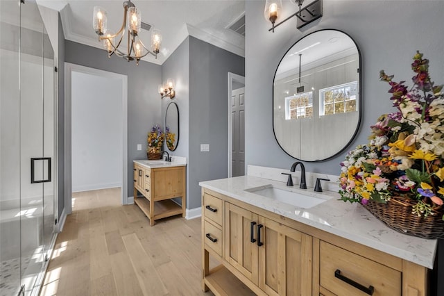 bathroom with crown molding, a sink, and a shower stall