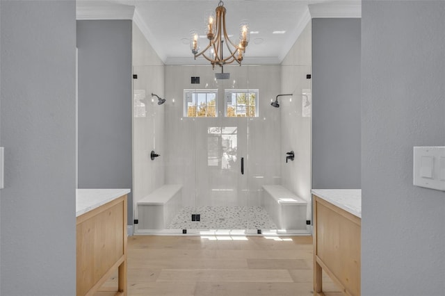 bathroom featuring ornamental molding, a stall shower, wood finished floors, and a notable chandelier