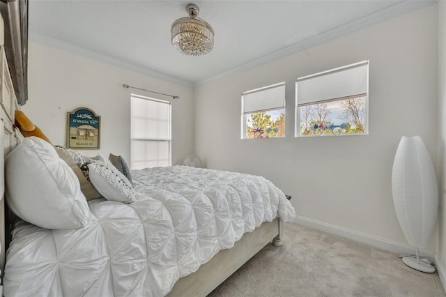 carpeted bedroom with ornamental molding and baseboards