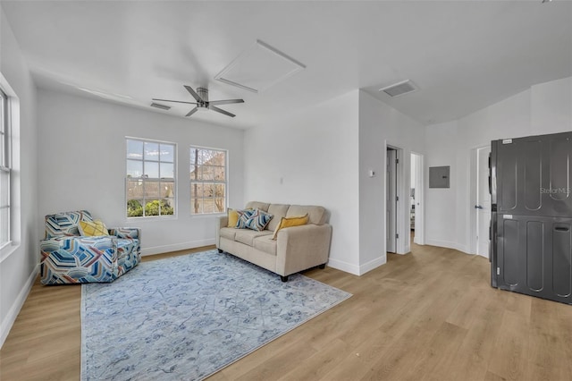 living area featuring light wood finished floors, electric panel, and visible vents