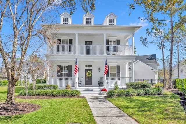 neoclassical / greek revival house with a porch, a front lawn, and a balcony