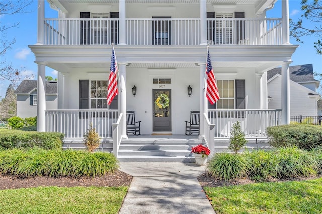 entrance to property featuring a porch and stucco siding