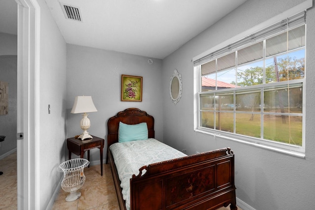 bedroom with tile patterned floors, visible vents, and baseboards