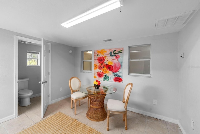 tiled dining area featuring baseboards and visible vents