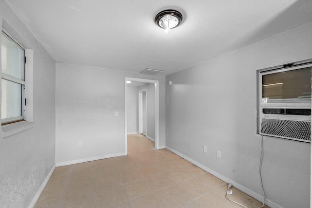 spare room featuring tile patterned flooring and baseboards