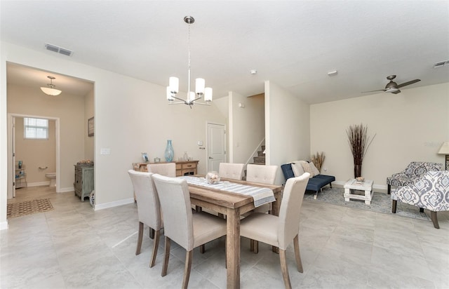 dining room featuring baseboards, stairs, visible vents, and ceiling fan with notable chandelier