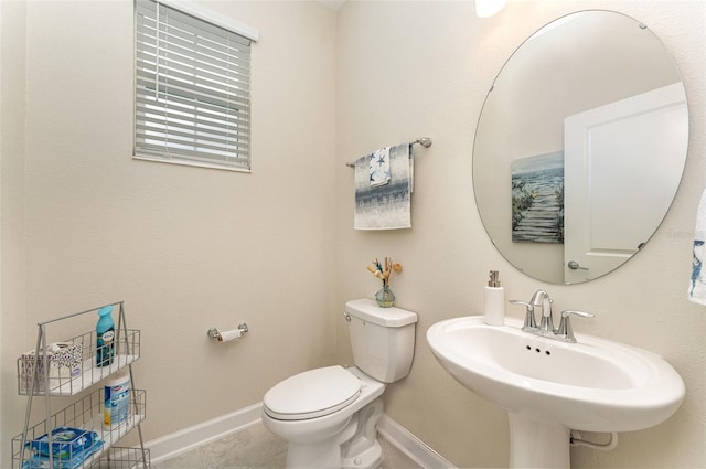 bathroom with tile patterned flooring, a sink, toilet, and baseboards