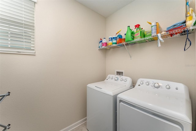 laundry area with laundry area, washing machine and dryer, and baseboards