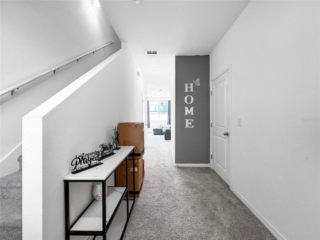 corridor with carpet, visible vents, and baseboards