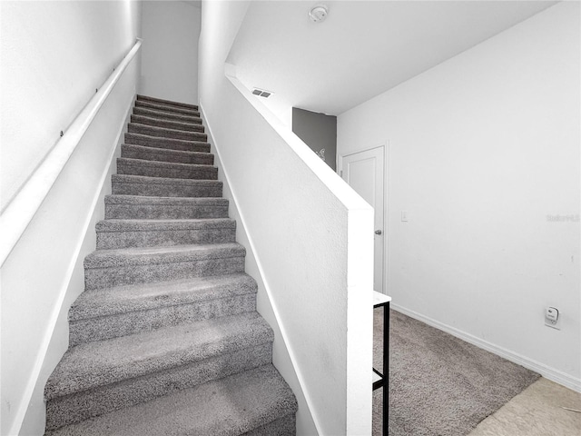 stairs with visible vents and baseboards