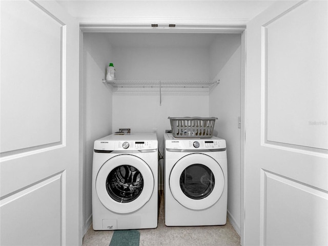 clothes washing area featuring laundry area and washer and clothes dryer