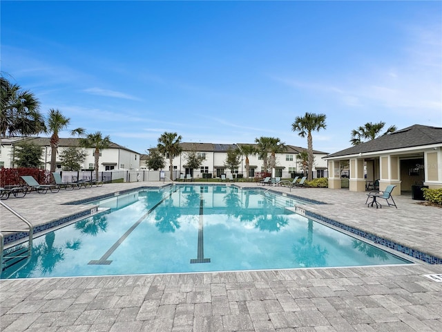 pool featuring a patio, fence, and a residential view