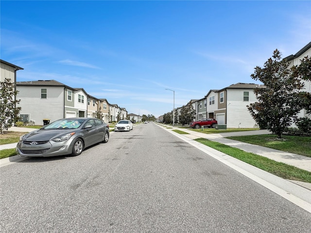 view of street featuring sidewalks, a residential view, and street lights