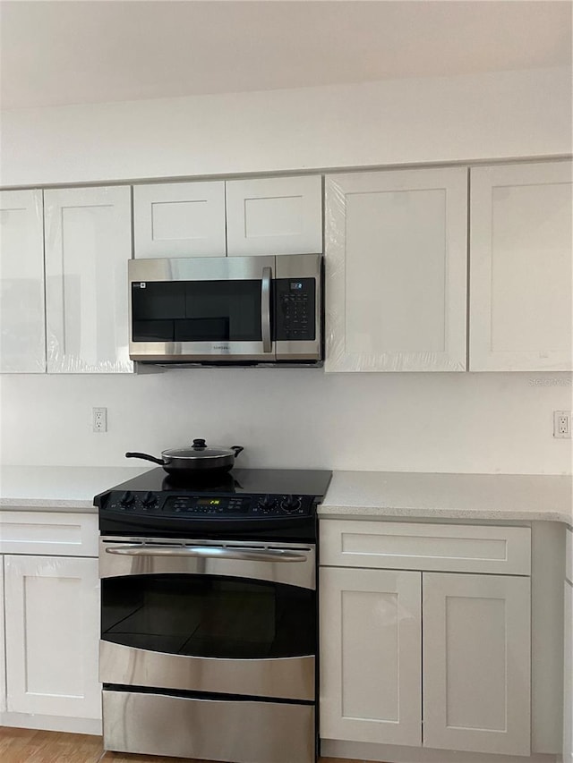 kitchen featuring light countertops, appliances with stainless steel finishes, and white cabinets