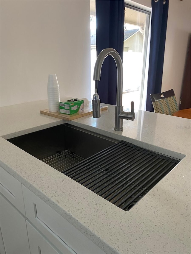 interior details featuring light stone countertops and a sink