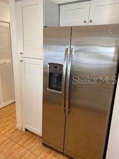 kitchen featuring white cabinets and stainless steel fridge with ice dispenser