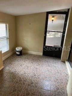 unfurnished room with baseboards