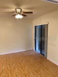 unfurnished room featuring ceiling fan, a textured ceiling, baseboards, and wood finished floors