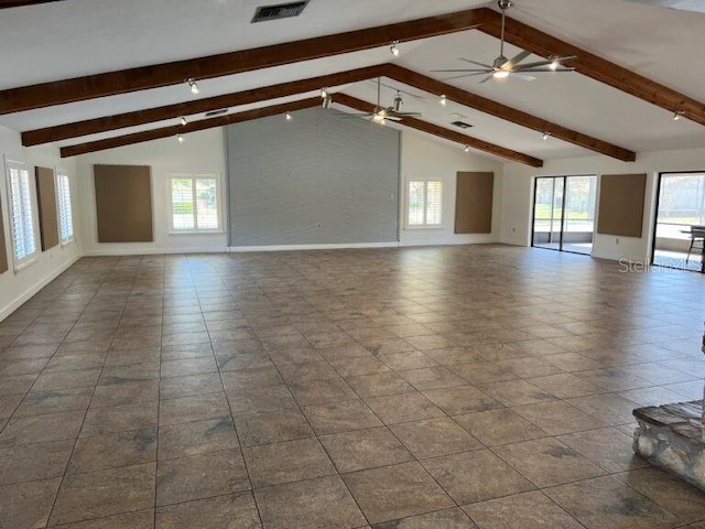 spare room with baseboards, visible vents, a wealth of natural light, and beamed ceiling