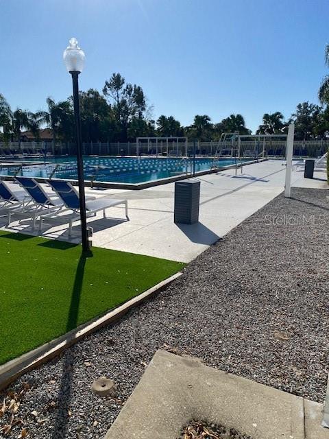 community pool with fence and a patio